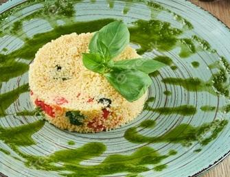 couscous with tomatoes pesto and basil on a blue plate on a wooden table healthy vegetarian food fitness nutrition close up view 207126 1979
